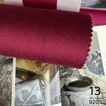 Close-up of a roll of red fabric with decorative elements in the background