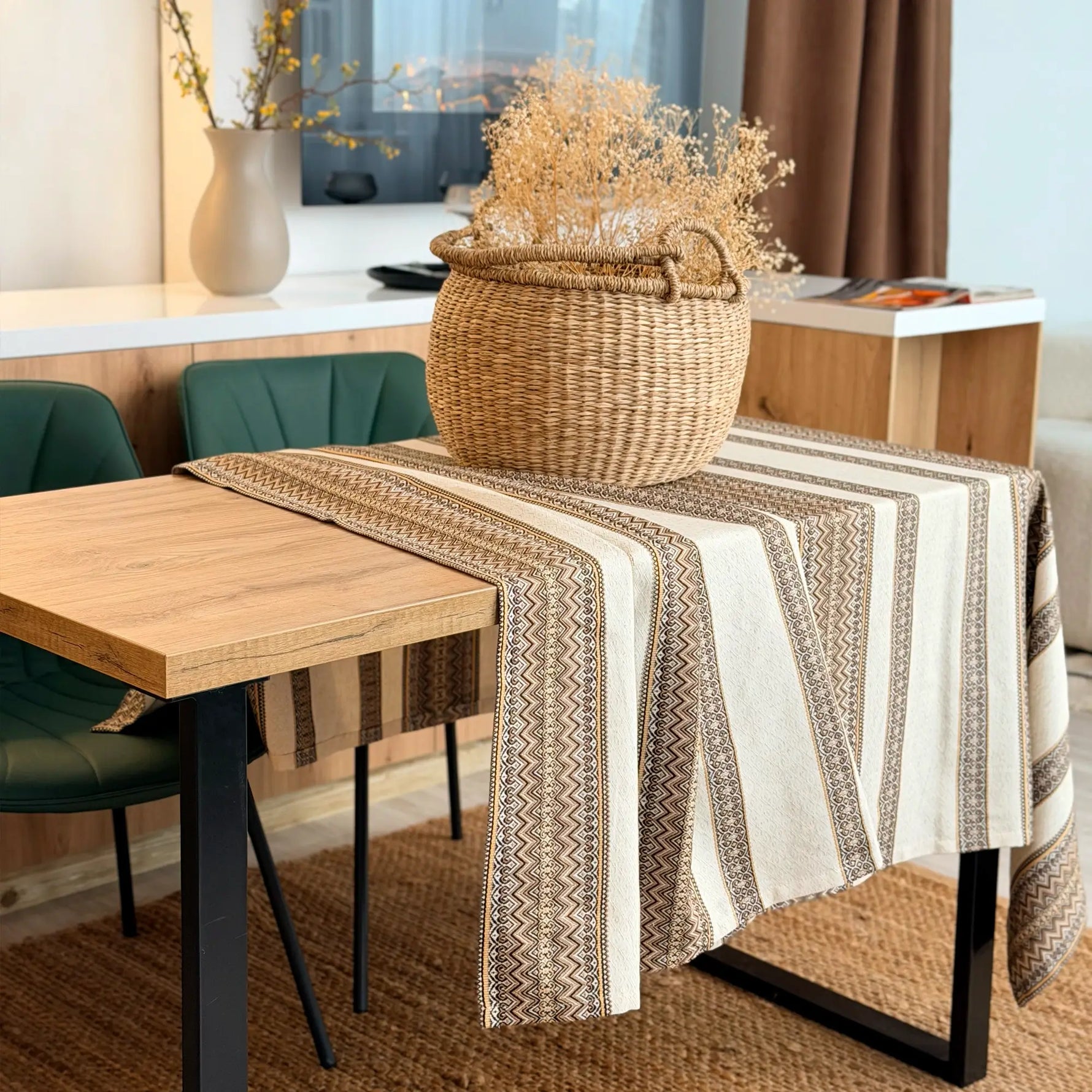 Dining table with a patterned tablecloth and decorative basket in a home setting.