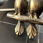 Bronze sculpture of two birds perched on a branch