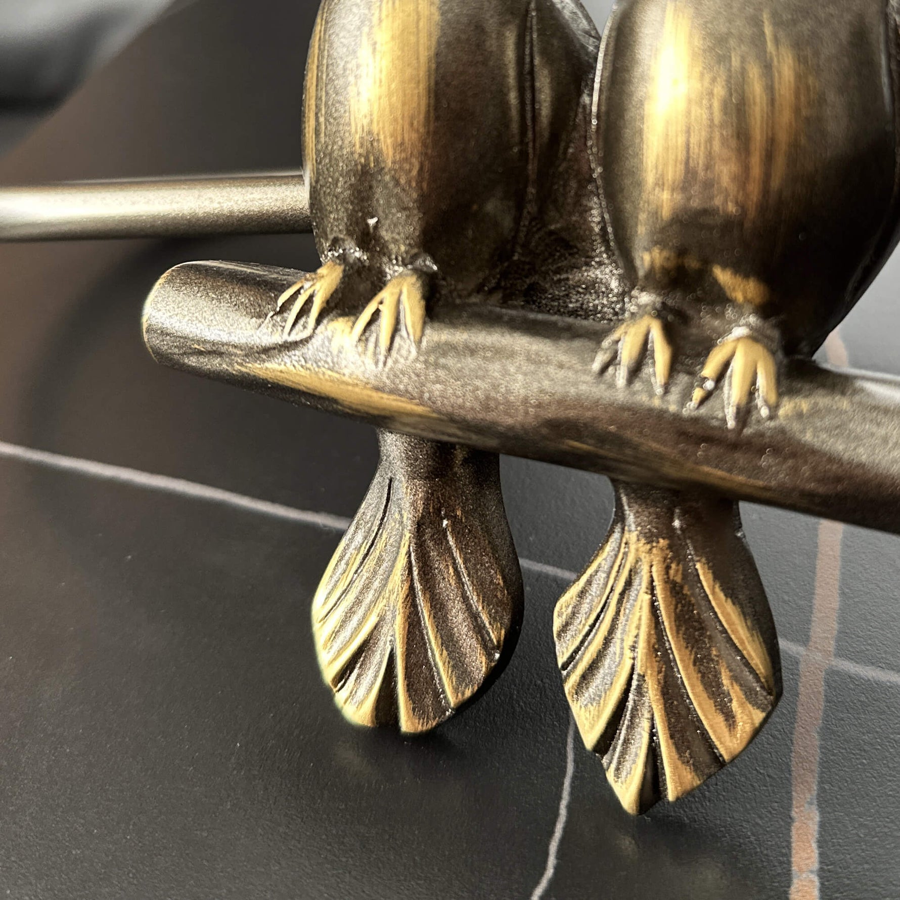 Bronze sculpture of two birds perched on a branch