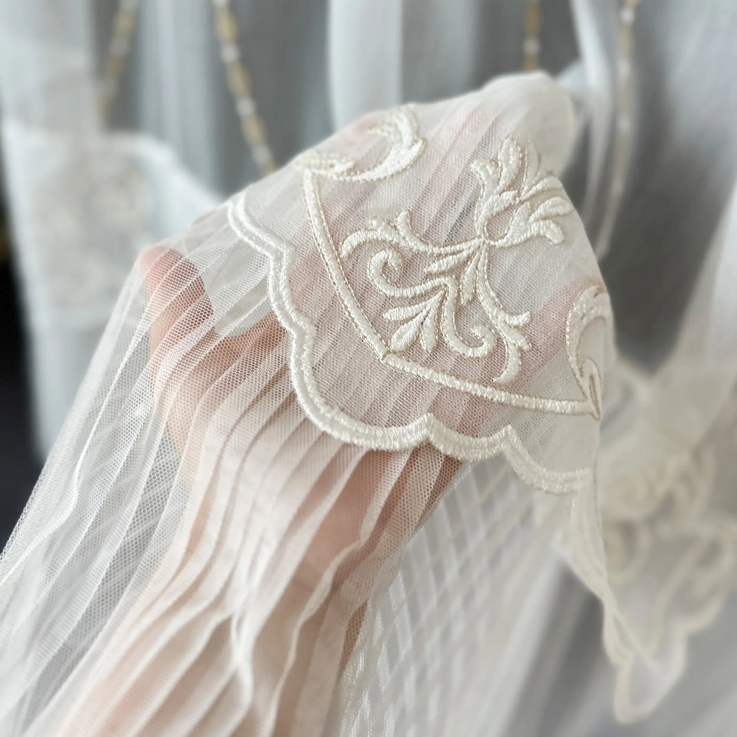 Close-up of a lace curtains fabric with damask floral patterns with pleated ruffle
