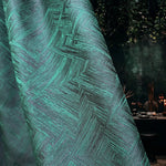 Close-up of a textured green fabric with a geometric pattern, blurred background