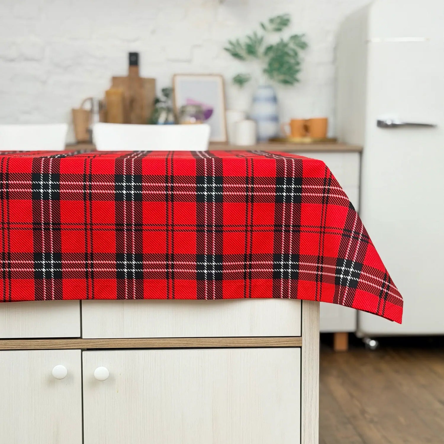 Red plaid tablecloth on a kitchen counter with a blurred background