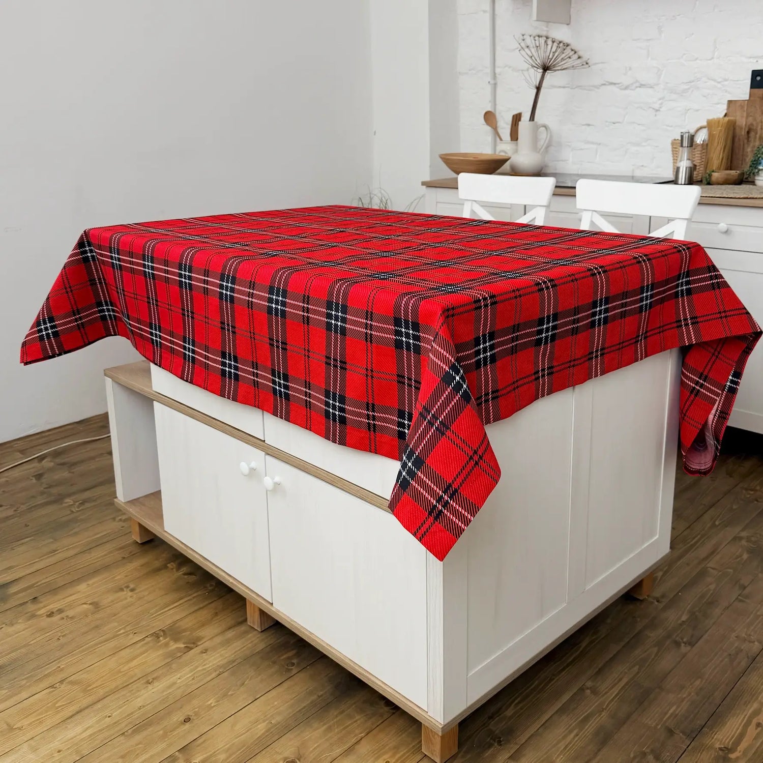 Red plaid tablecloth on a white cabinet in a kitchen setting