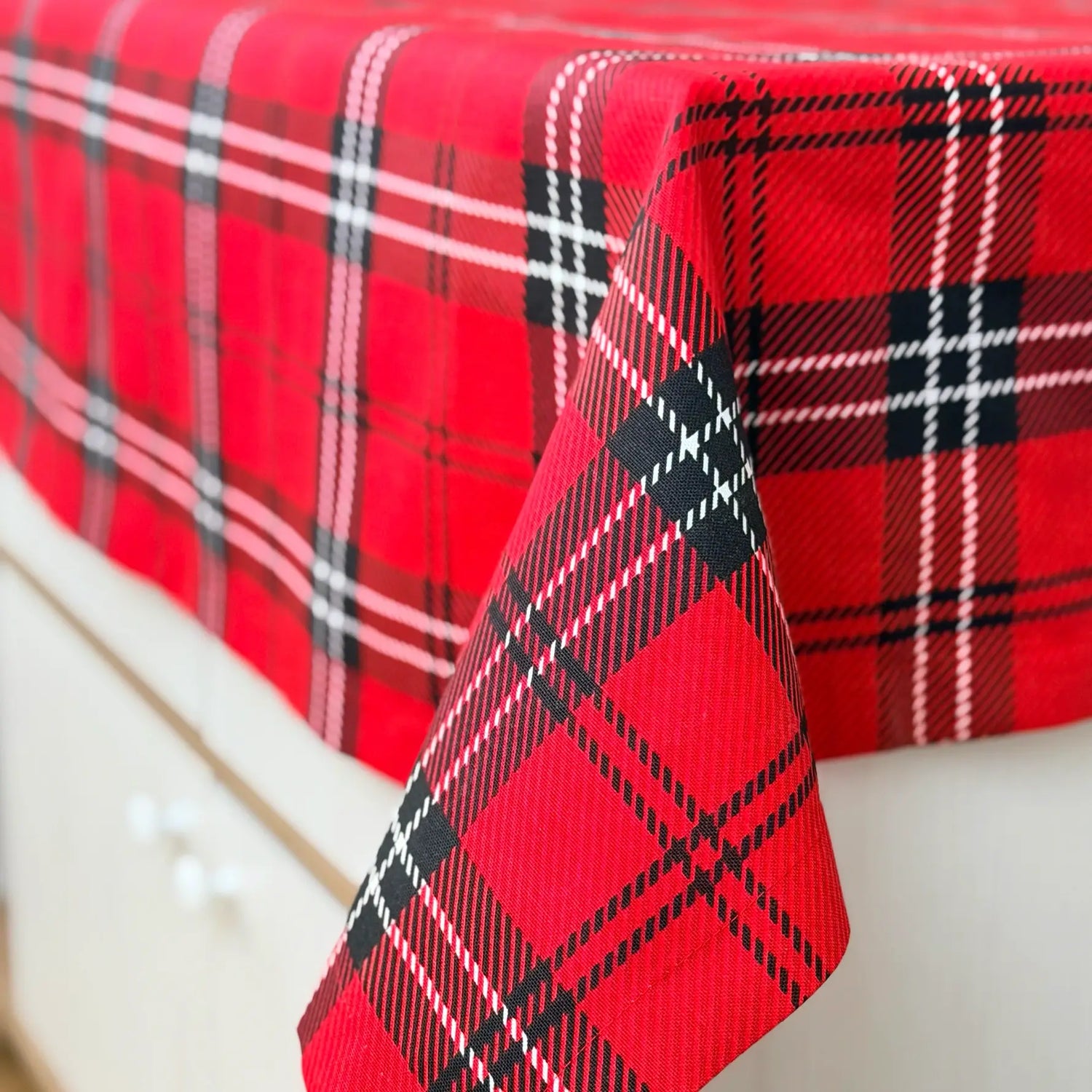 Red and black plaid tablecloth on a white surface