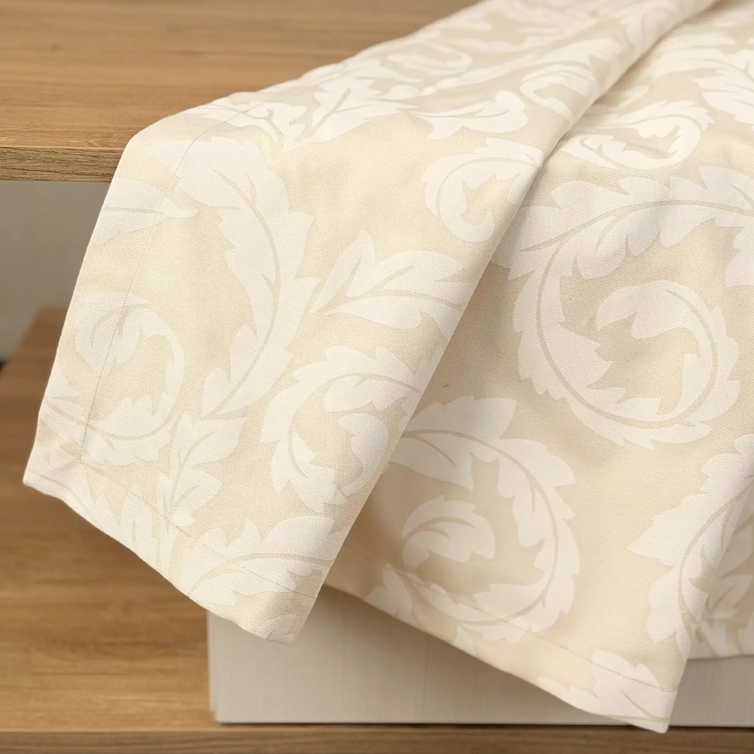 Beige patterned fabric draped over a wooden surface