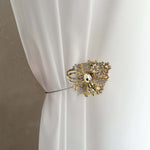 Decorative gold curtain tieback on a white curtain