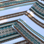 Close-up of patterned fabric with geometric designs on a light blue background