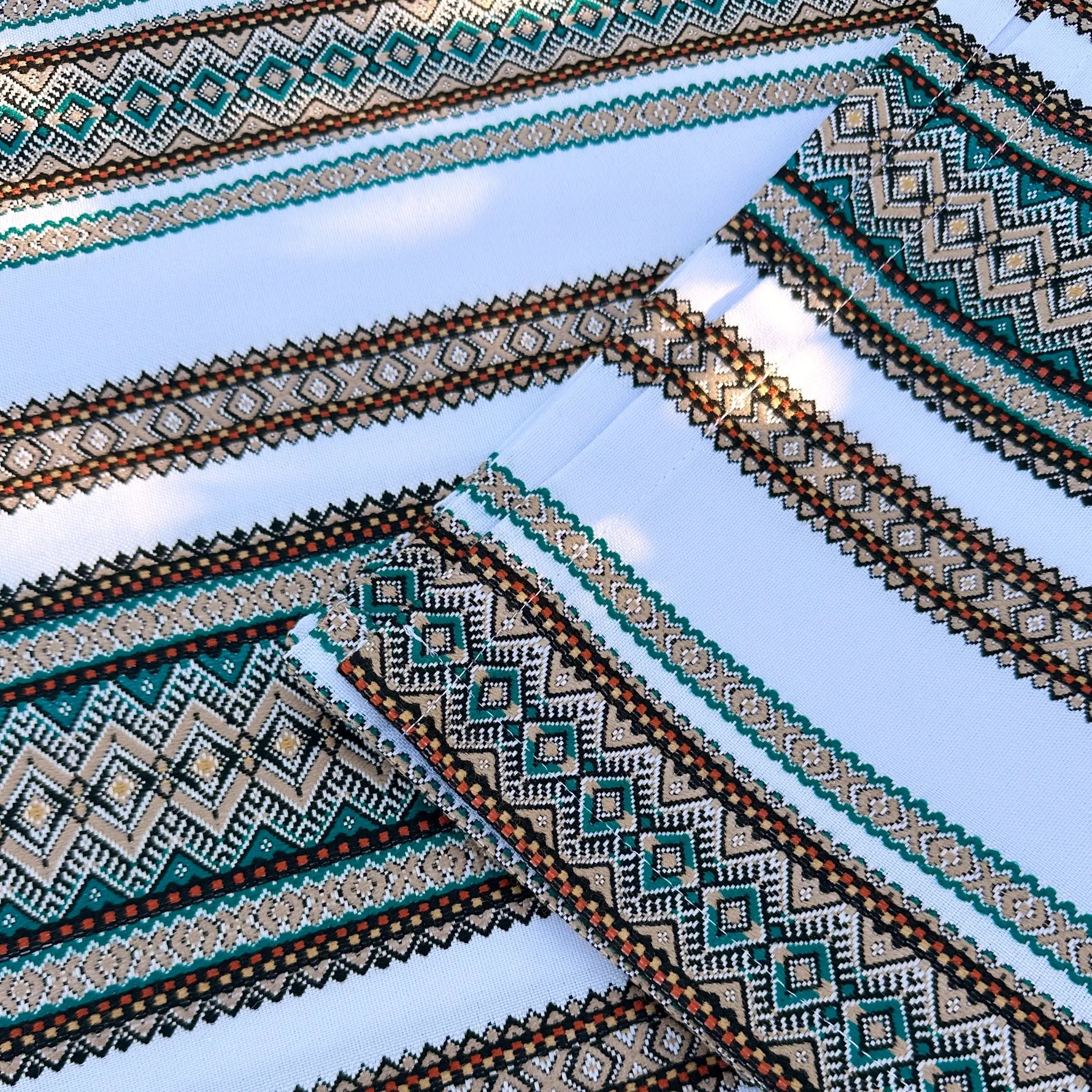 Close-up of patterned fabric with geometric designs on a light blue background
