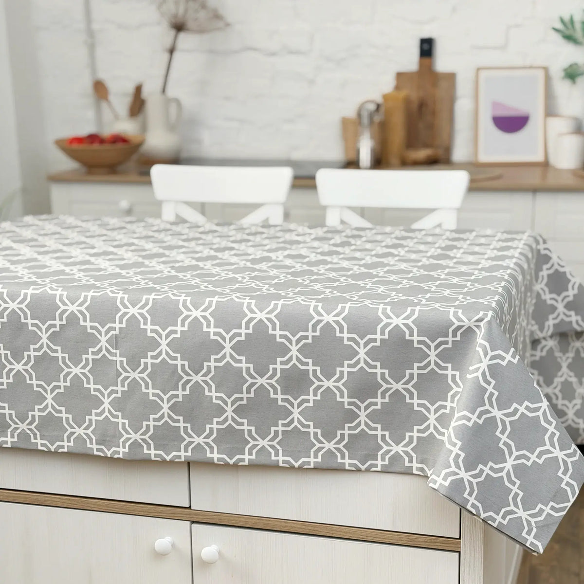 Gray geometric patterned tablecloth on a dining table in a kitchen setting.