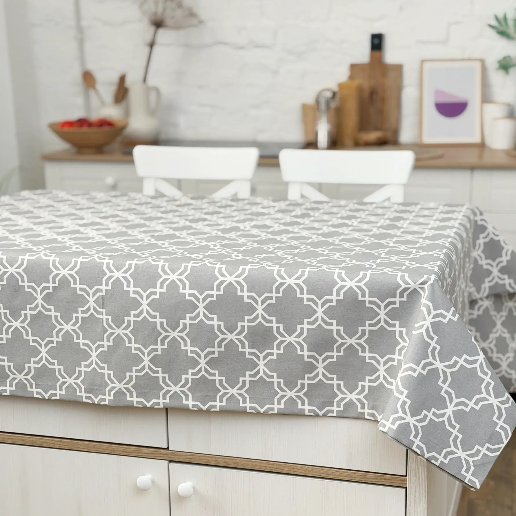 Gray geometric patterned tablecloth on a dining table in a kitchen setting.