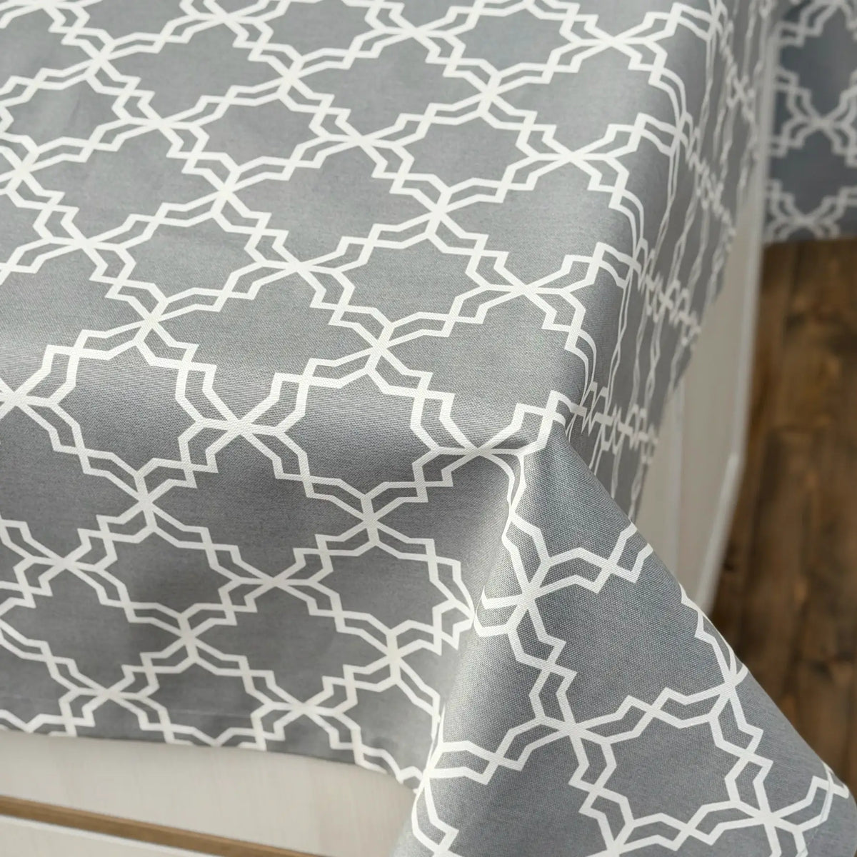 Gray tablecloth with white geometric pattern on a wooden surface