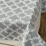 Gray tablecloth with white geometric pattern on a wooden surface