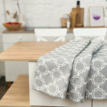 Dining table with a gray patterned tablecloth in a kitchen setting