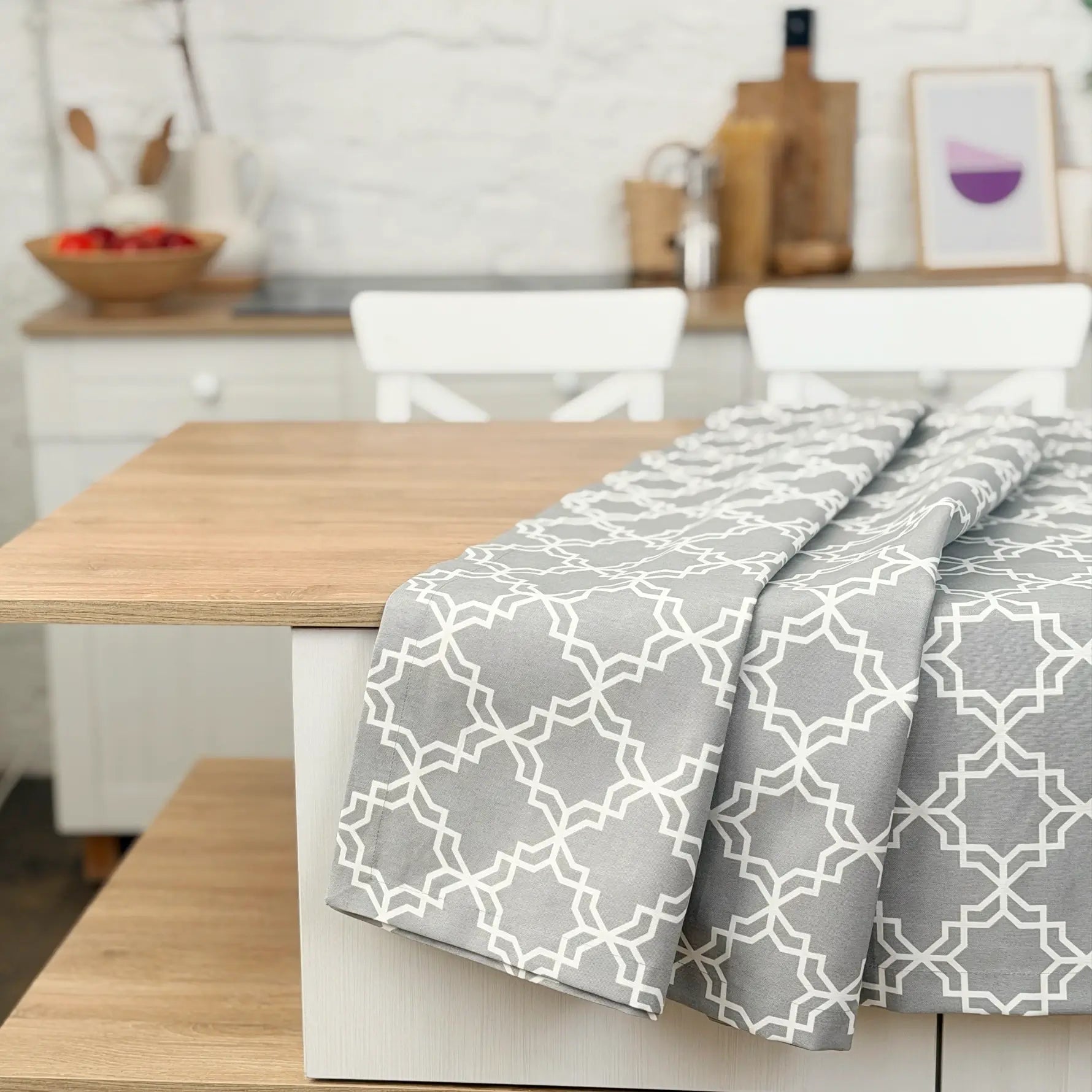 Dining table with a gray patterned tablecloth in a kitchen setting
