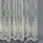 Embroidered lace fabric with intricate patterns on a gray background