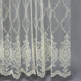 Embroidered lace fabric with intricate patterns on a gray background
