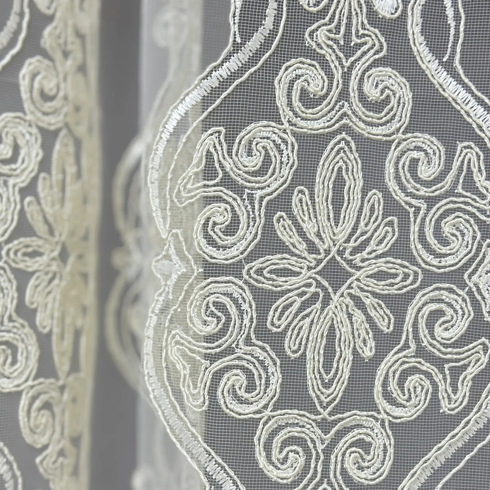 Close-up of decorative lace fabric with intricate patterns.