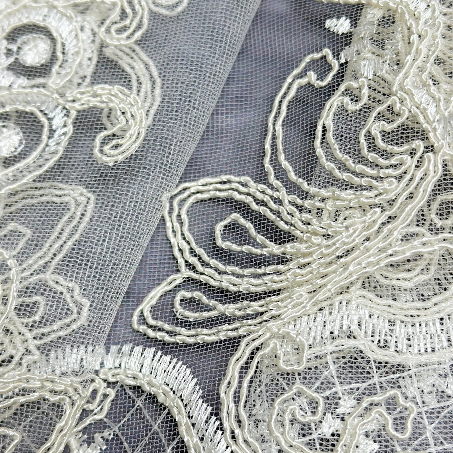 Close-up of intricate lace fabric with detailed embroidery.