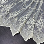White lace fabric with intricate patterns on a dark background