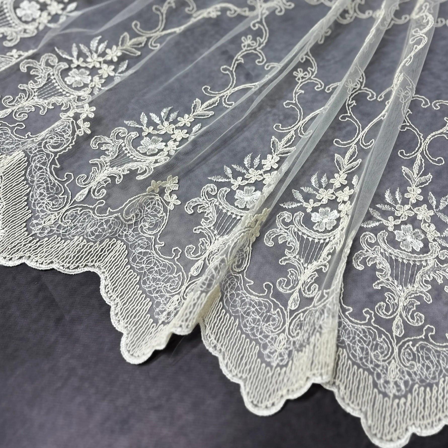 White lace fabric with intricate patterns on a dark background