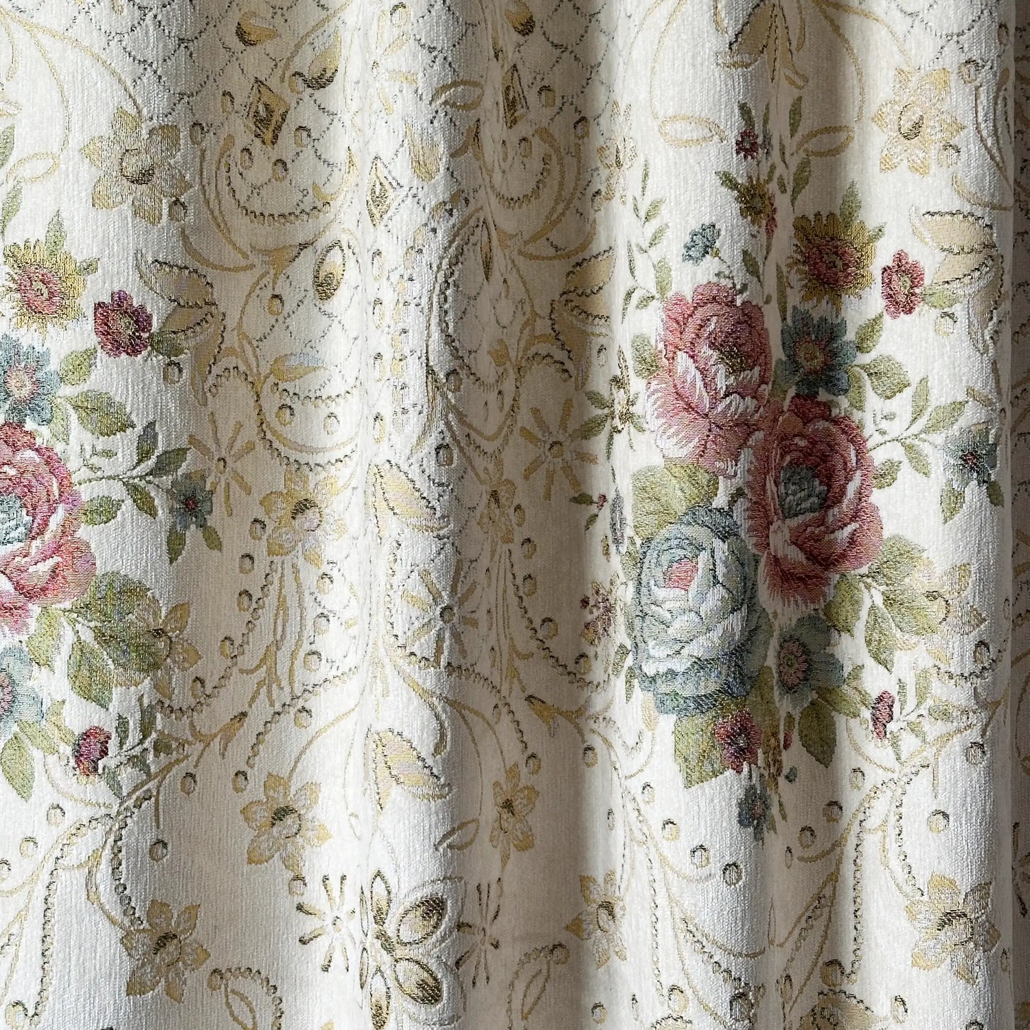 Floral and paisley patterned fabric with embroidered roses.