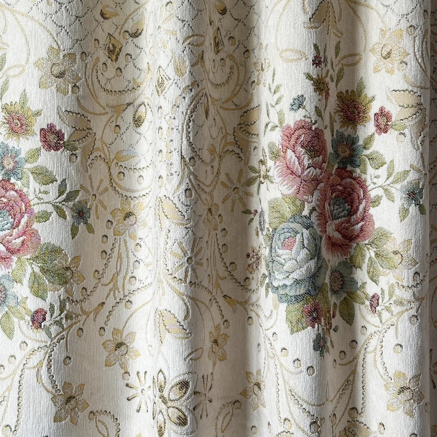 Floral and paisley patterned fabric with embroidered roses.
