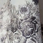 Close-up of silver floral lace fabric on a white background