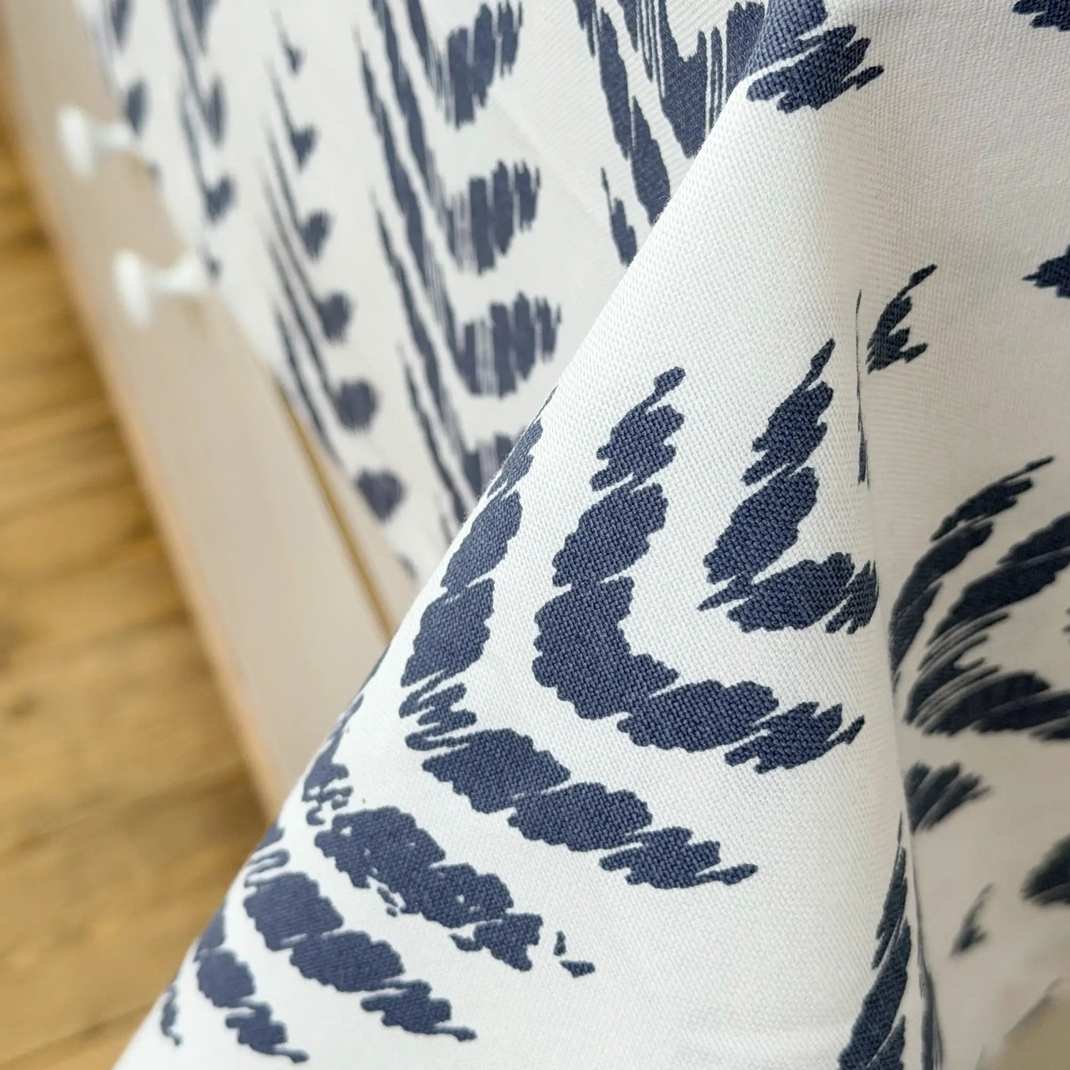 Close-up of fabric with blue leaf pattern on a white background
