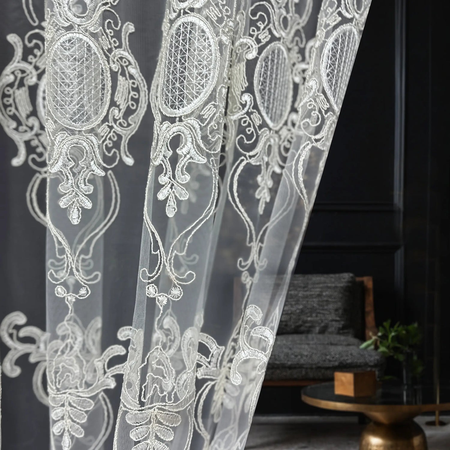 White lace curtain with intricate patterns in a room setting