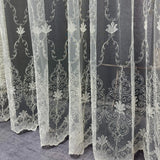 White embroidered lace curtains on a dark background