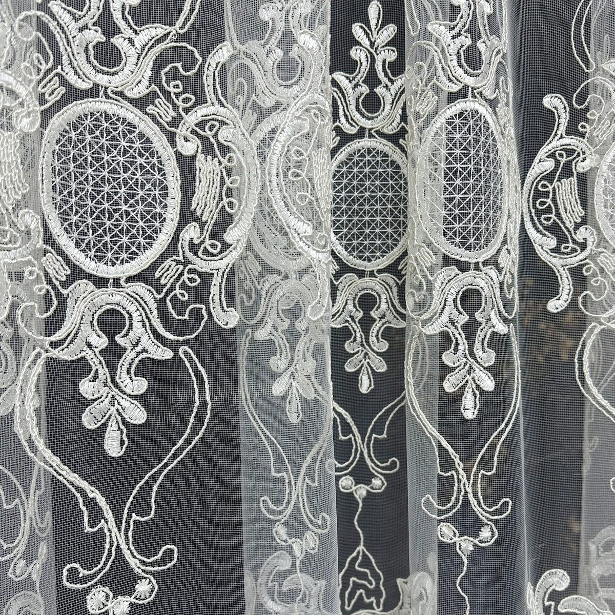Decorative lace fabric with intricate patterns on a black background