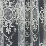 Decorative lace fabric with intricate patterns on a black background