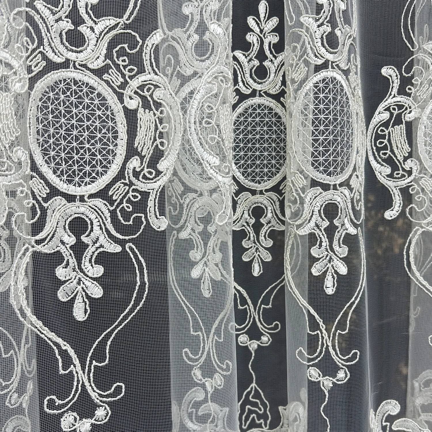 Decorative lace fabric with intricate patterns on a black background