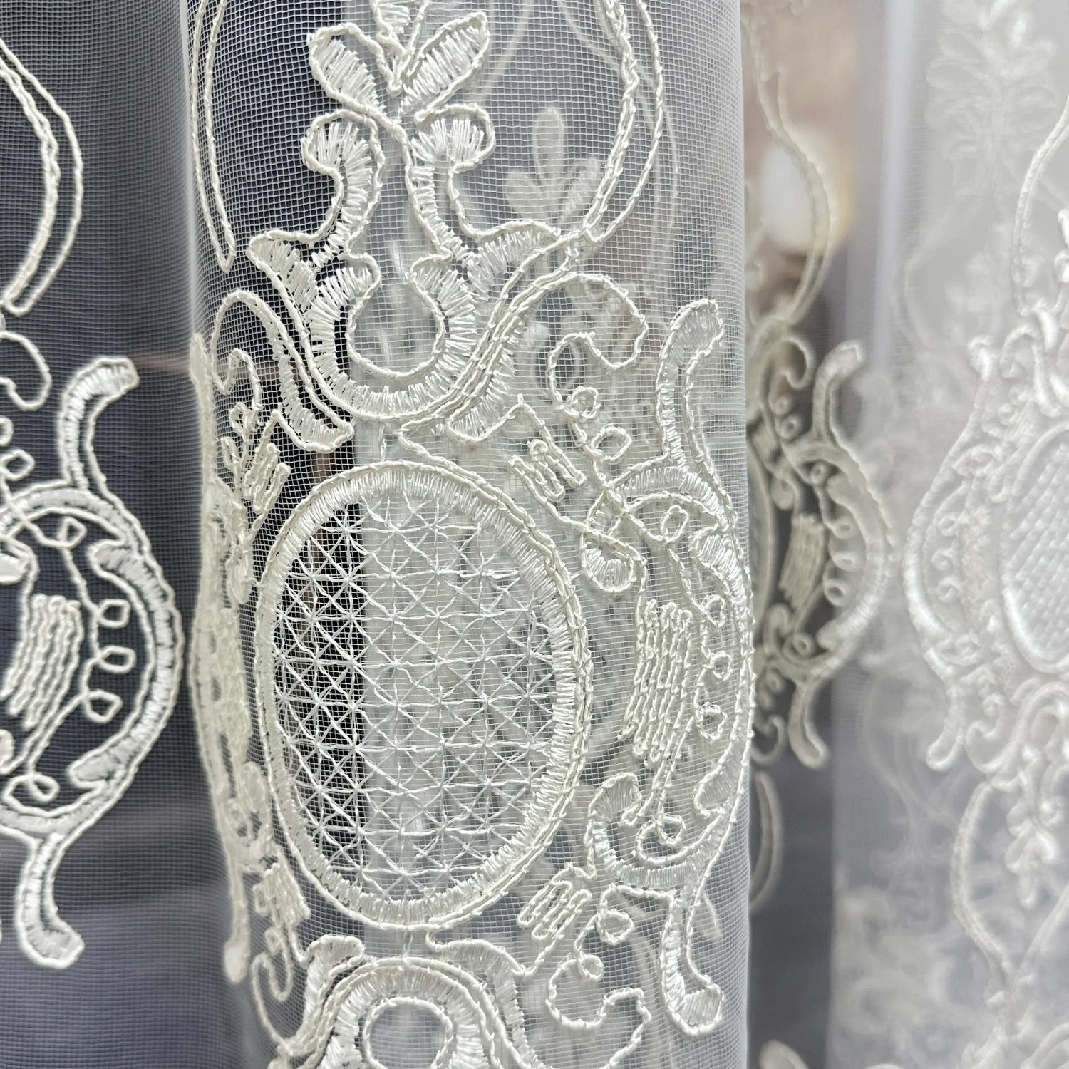 Close-up of intricate lace fabric with detailed patterns.