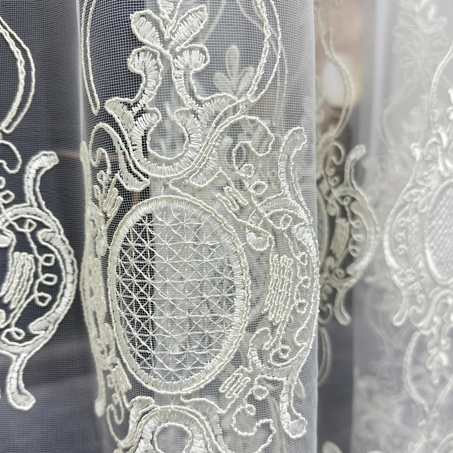 Close-up of intricate lace fabric with detailed patterns.