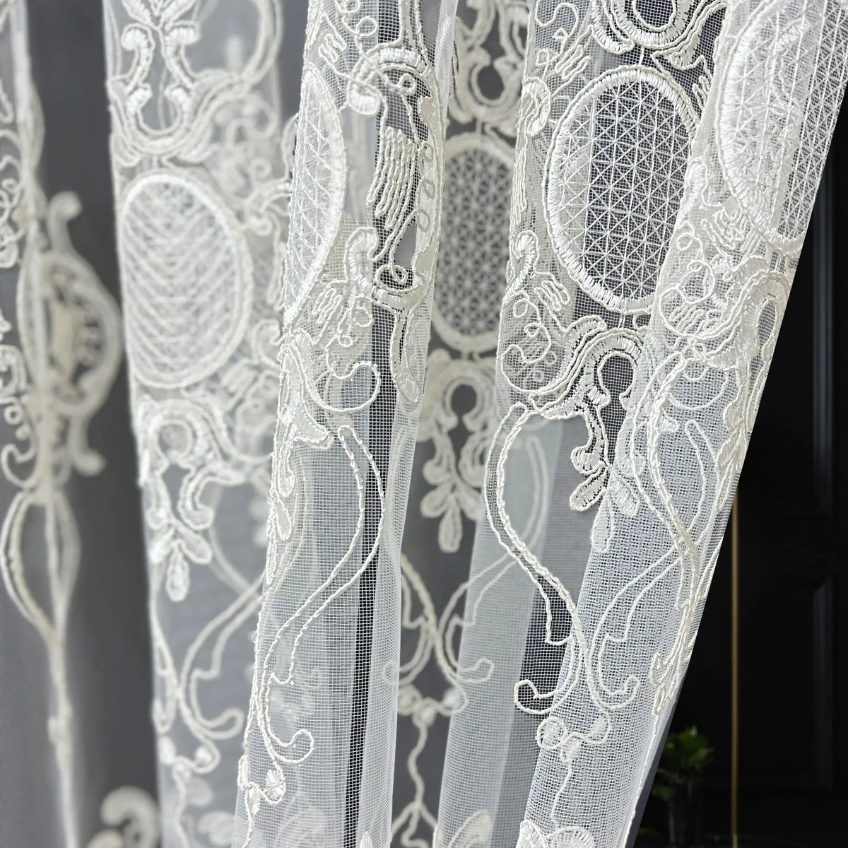 Close-up of white lace fabric with intricate patterns on a dark background