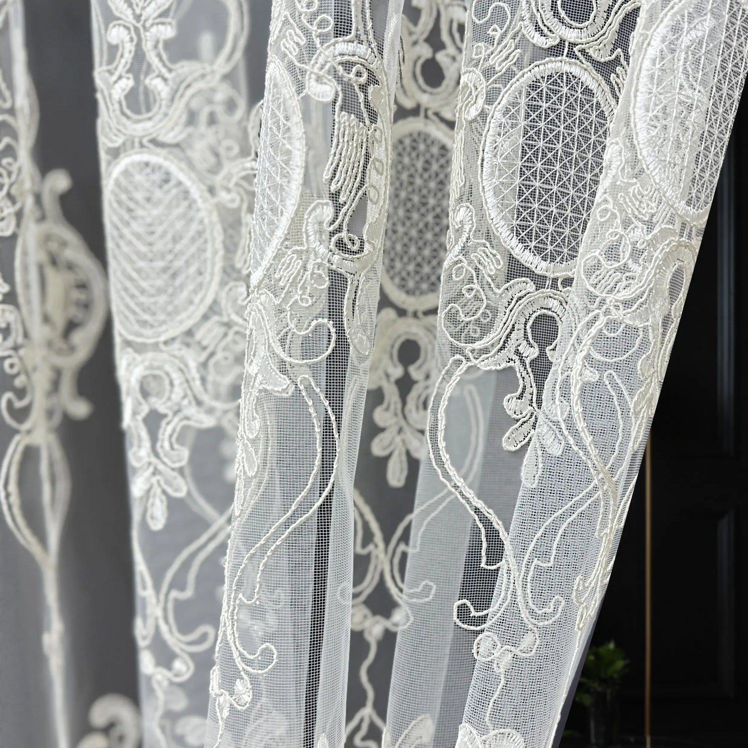 Close-up of white lace fabric with intricate patterns on a dark background
