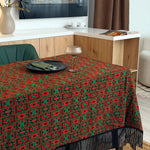Dining table with a red and green patterned tablecloth in a modern kitchen setting.