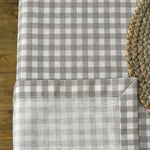 Gray and white checkered tablecloth on a wooden table with a woven placemat.