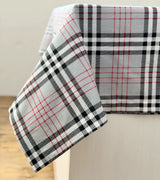 Plaid tablecloth with red, black, and white pattern on a neutral background