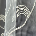 Close-up of a textured fabric with embroidered patterns on a dark background