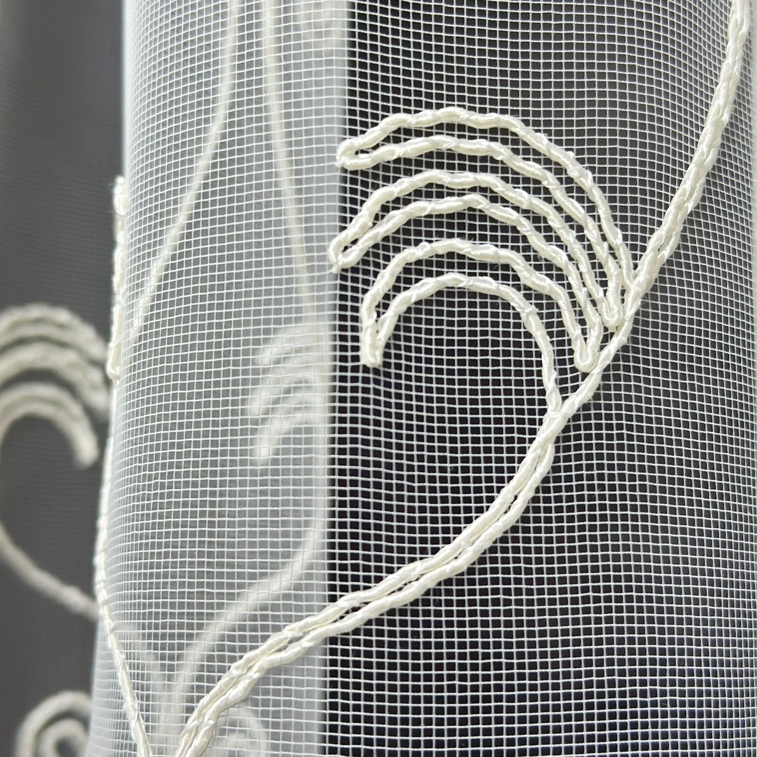 Close-up of a textured fabric with embroidered patterns on a dark background