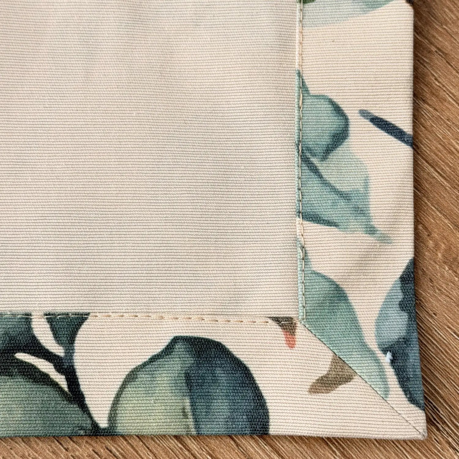 Close-up of a floral-patterned fabric corner on a wooden surface