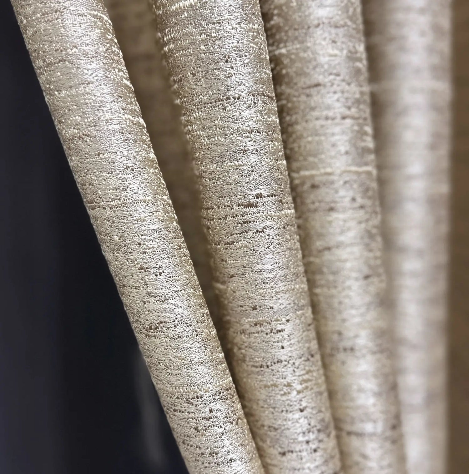 Close-up of textured beige fabric with a dark background