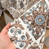 Patterned fabric held by a hand with a blurred background