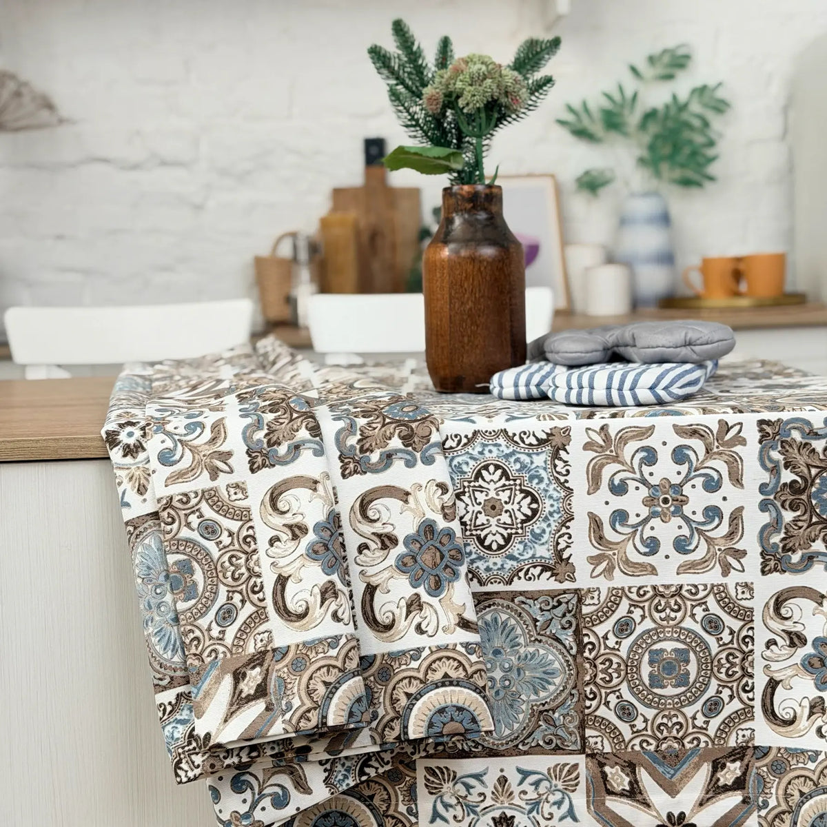 Patterned tablecloth on a dining table with decorative items in a kitchen setting
