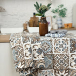 Patterned tablecloth on a dining table with decorative items in a kitchen setting