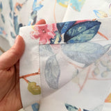 Close-up of a hand holding floral fabric with a colorful pattern.
