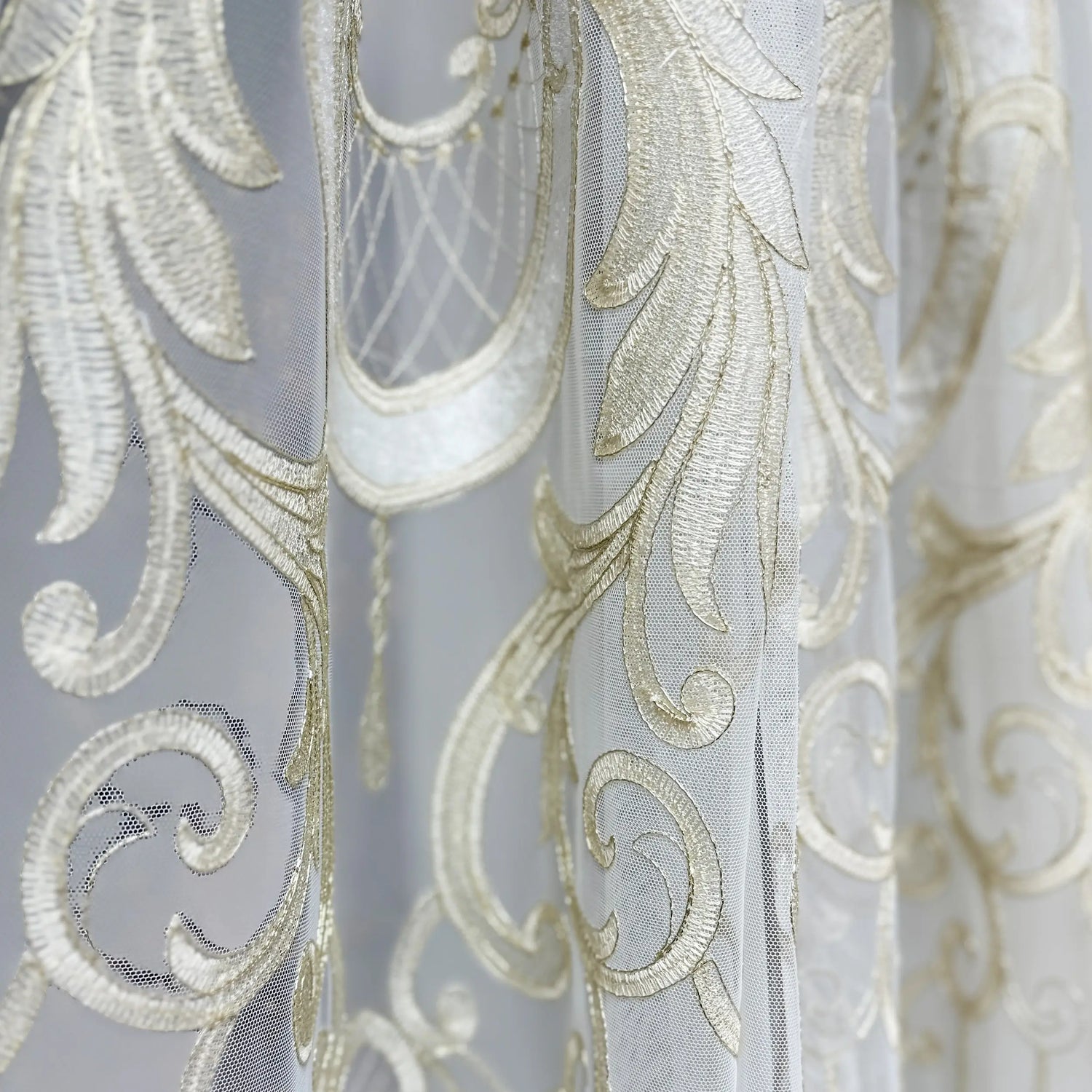 Close-up of decorative fabric with intricate gold patterns on a light gray background